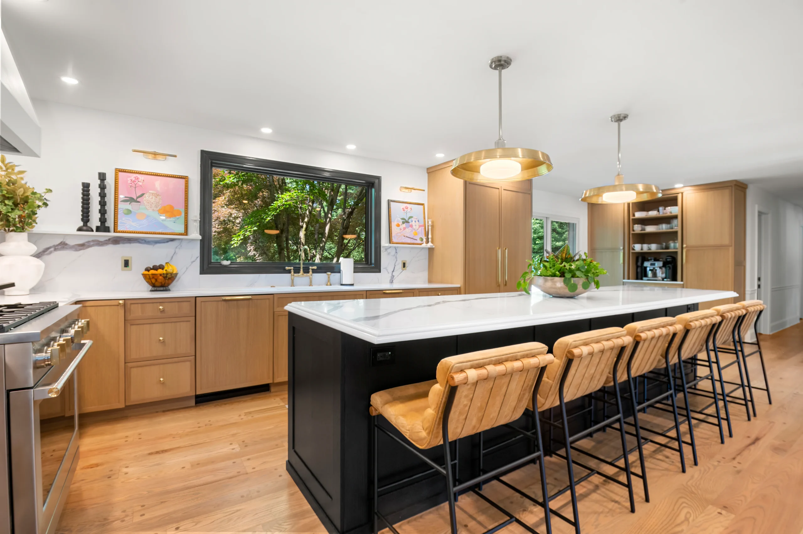 Local countertops near you featuring a Calacatta Corchia quartz island with black cabinets and brass lighting